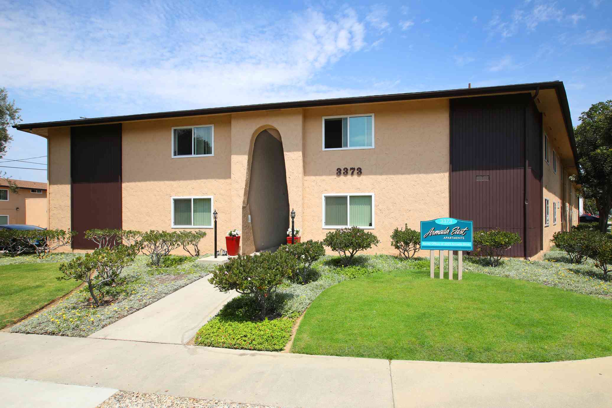 landscaped entrance and manicured green lawn
