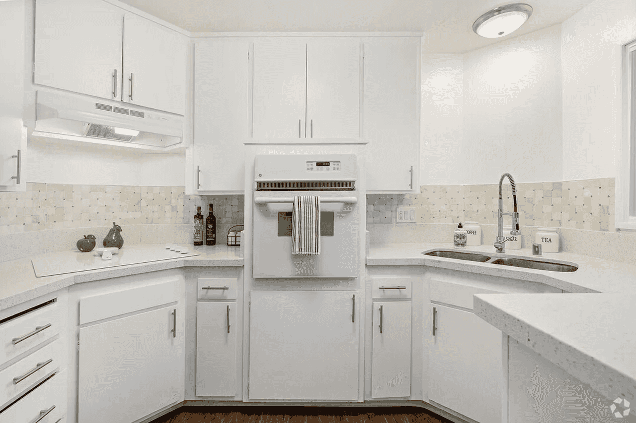 renovated kitchen with white cabinetry and tile backsplash