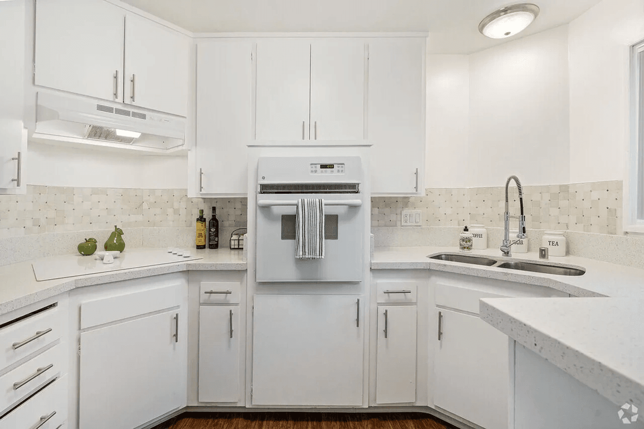 Armada Apartments renovated kitchen with white cabinetry and tile backsplash