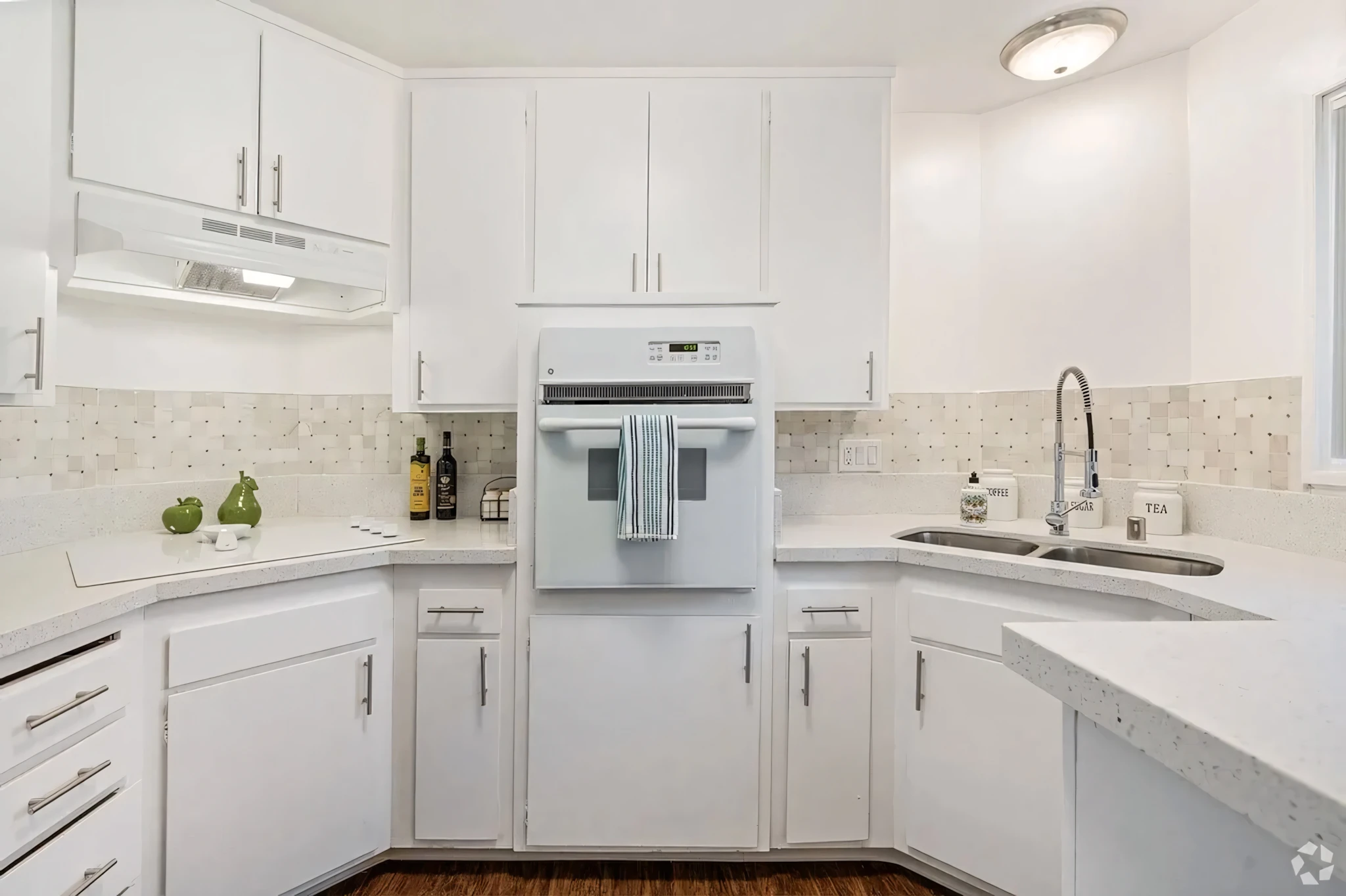 Armada Apartments renovated kitchen with white cabinetry and tile backsplash